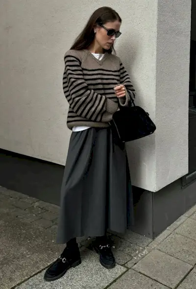 @annabelrosendahl wears a grey and black striped jumper, grey midi skirt, black loafers and sunglasses
