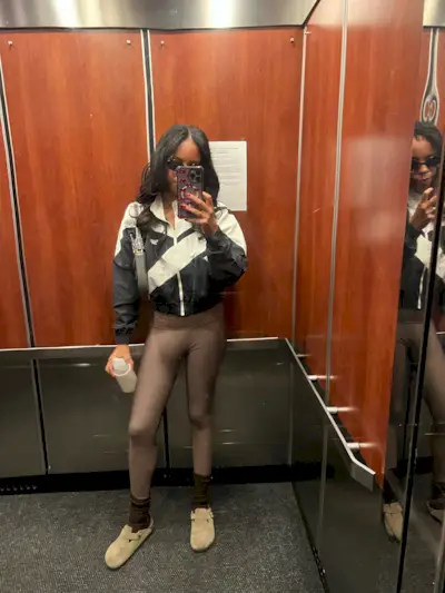 woman wearing leggings and windbreaker with birkenstocks