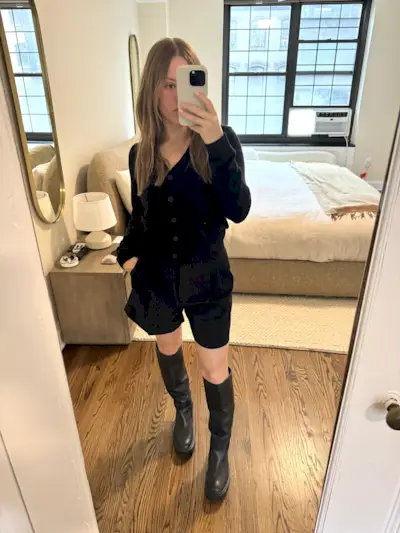 Nikki Chwatt wears Aritzia effortless shorts mid thigh with a black cardigan and black lug-sole knee high boots.