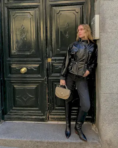 Woman wearing black jeans and tall black boots.