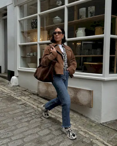 Jessica in a cropped brown jacket, jeans and trainers