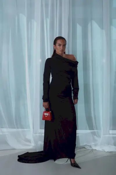 a photo showing black tie attire for women with a woman wearing a black long gown and black pointed heels