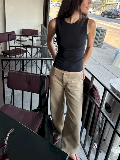 @ilanatorbiner wearing a black tank top, flip flops, and khaki Still Here Sport jeans.