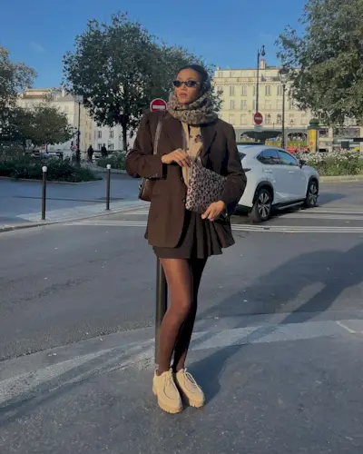 @lenafarl wearing a brown blazer and mini skirt with leopard print accessories