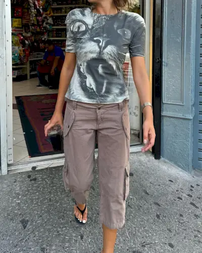 Influencer @rubylyn_ wears long shorts with a grey t-shirt with a cat's face on its front.