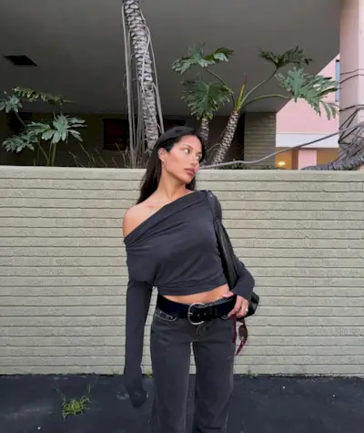 Influencer @discodaydream wears faded black jeans with a black off-the-shoulder top.