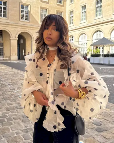 Influencer wears a polkadot blouse.