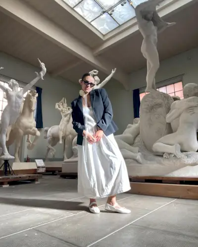 Influencer wears white ballet flats.