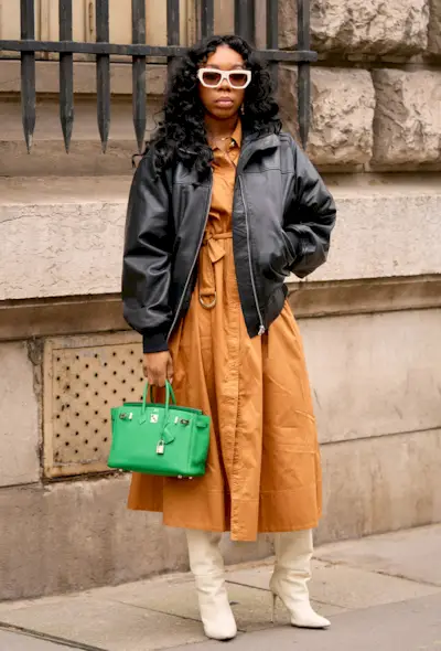 a street-style photo of a woman carrying a Hermés bag in a story about how to buy an hermés bag