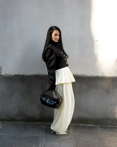 @oumaymaboumeshouli wearing a Khaite button-up jacket with ivory sheer genie pants and matching heels.