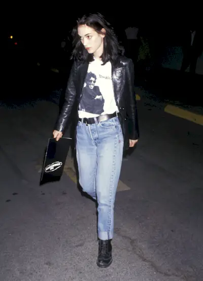 An image of Winona Ryder wearing a black leather jacket, white t-shirt, black boots and jeans to a film premiere in 1991, one of the most iconic '90s outfits.