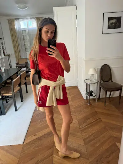 Anne wears a red t-shirt, red, athletic shorts and flats.