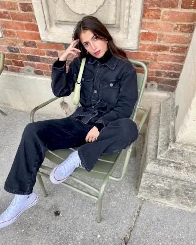 @tamaramory wears a denim jumpsuit, black roll-neck top and Converse
