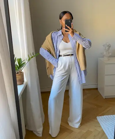 Woman wears striped shirt, white tank top, white trousers