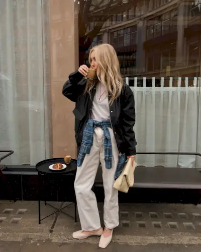 Woman wears light jacket, light jeans, and ballet flats