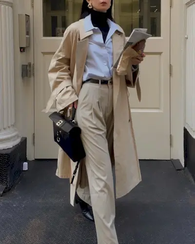 Woman wears black rollneck, white shirt and tailored trousers