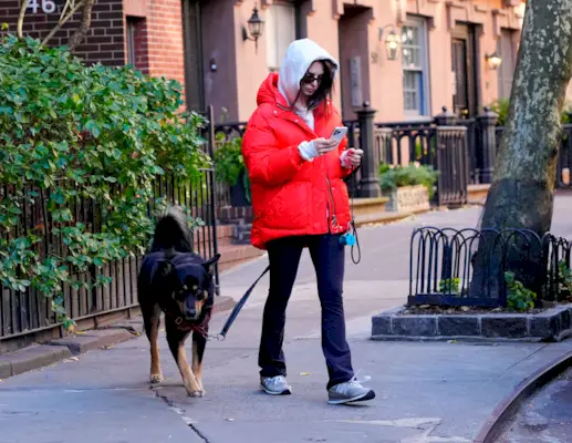 Photo of EmRata walking dog in New Balance 574 sneakers.