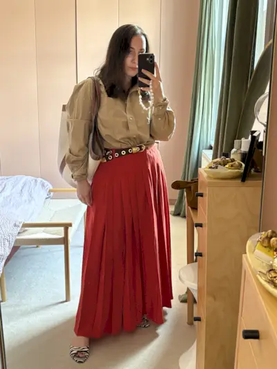 Mommy's Reviews Editor in Chief @hannahalmassi wears a red pleated maxi skirt with a tan shirt