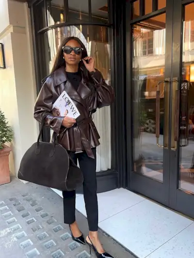 Influencer Lorna Symphony wearing a leather brown jacket and holding a brown bag