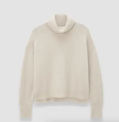 Lucy Williams in a striped T-shirt, white jeans, and boat shoes.