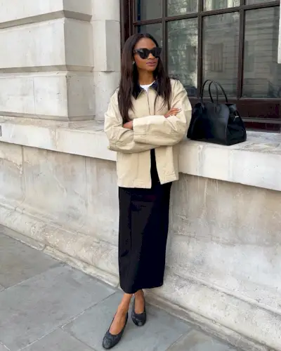 Woman wears cotton jacket, black skirt and ballet flats