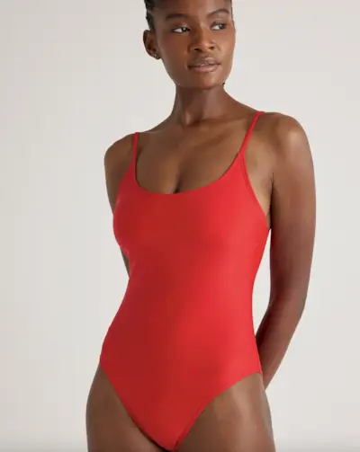 Sabrina Carpenter smiles and looks away from the camera wearing a beige jacket