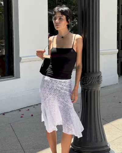 Woman in black camisole and white lace skirt