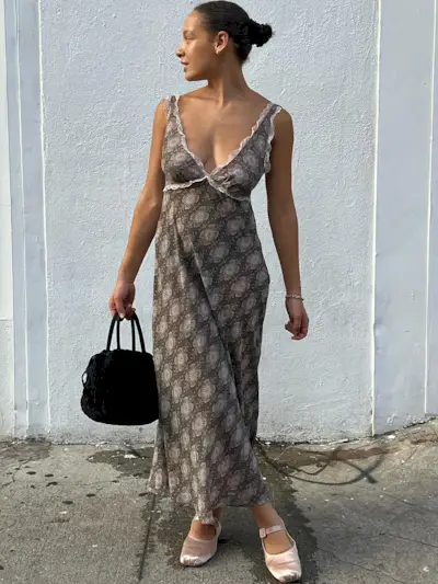 a photo of a woman wearing a printed slip maxi dress and pink satin ballet flats
