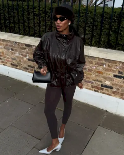 Marilyn wears a cinh-waist leather coat, black leggings, and white pumps.