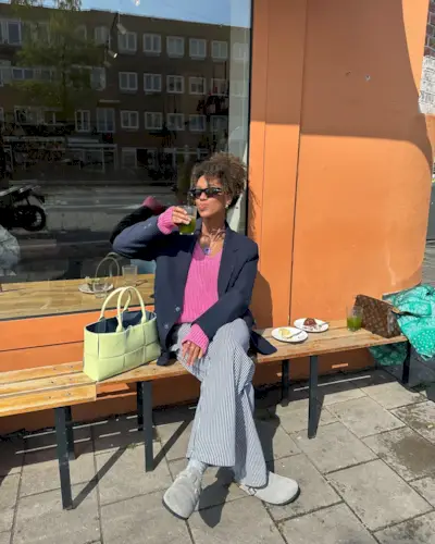 Woman wearing striped pants and a pink sweater