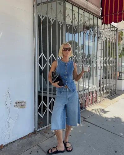 A woman wearing a denim vest and denim shorts