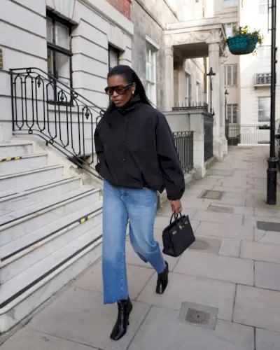 @nlmarilyn wears black bomber jacket, jeans, black boots and black bag