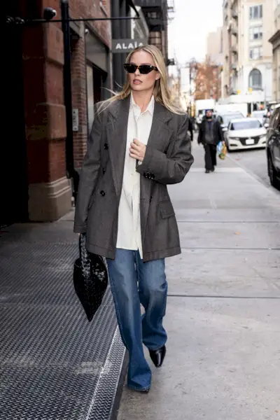 An image of Margot Robbie wearing a woven leather bag.