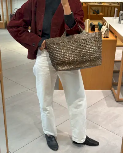 An image of @smythsisters wearing a woven leather bag.