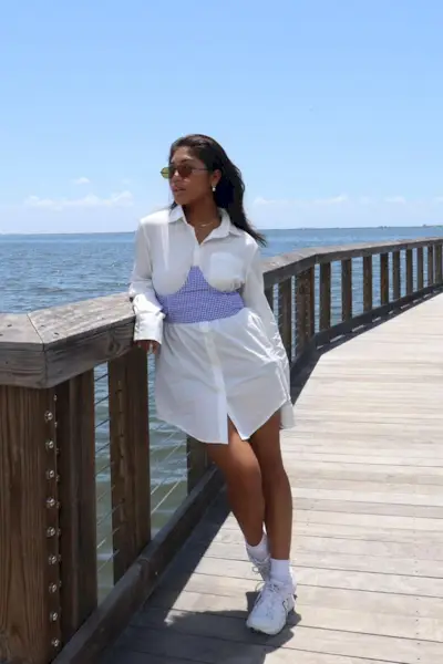 a woman's corset top outfit with a printed bustier cup styled over an oversize white button-down shirt dress