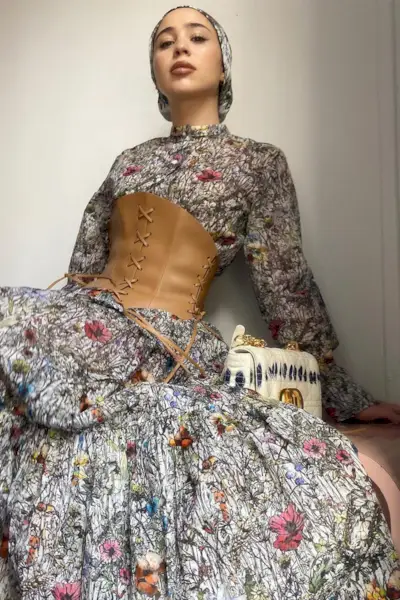 a woman's corset top outfit with a brown leather bustier over a maxi floral dress