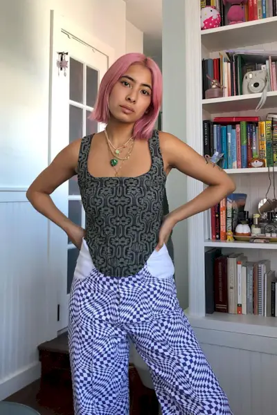a woman's corset top outfit with a printed bustier styled with contrasting printed pants and stacked necklaces