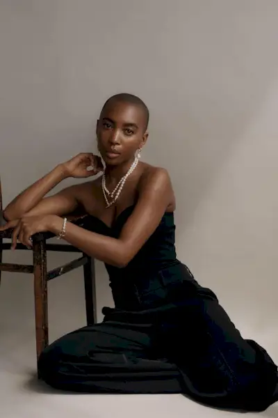 a woman's corset top outfit with a black corset styled with matching black pants and layered jewelry