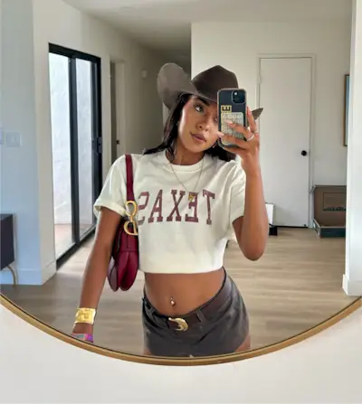 Woman wearing a Texas t-shirt and micro shorts.