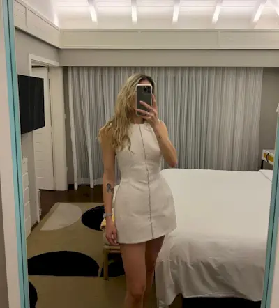 Eliza Huber wearing a white Tory Burch sculpted minidress in a mirror selfie.