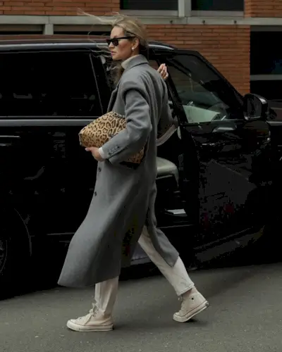 @anoukyve wearing white jeans, converse, long grey coat and holding a leopard print bag
