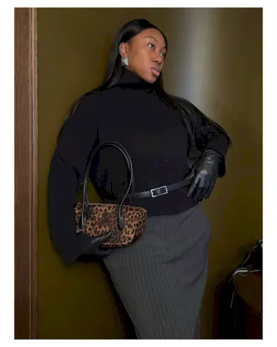 @nnennaechem wearing a pinstripe skirt, turtleneck jumper and a leopard print bag