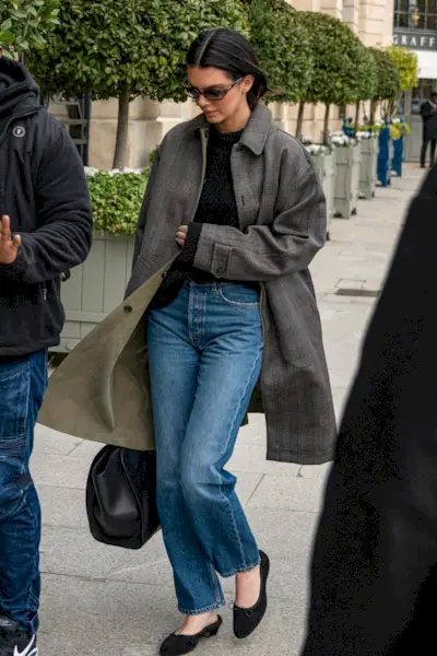 Kendall Jenner is seen in Paris after a L'Oréal shoot wearing a plaid car coat, jeans, and ballet flats.