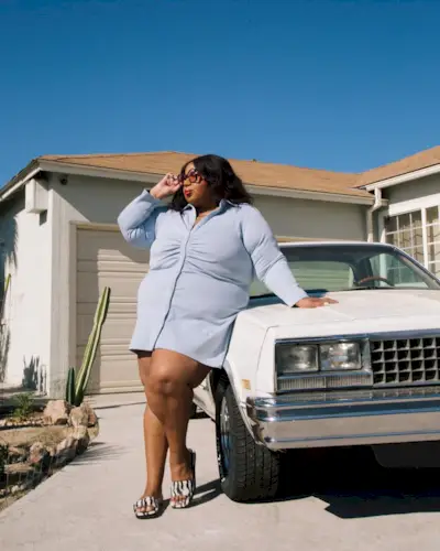 Woman wearing a blue button-down dress with printed sandals.
