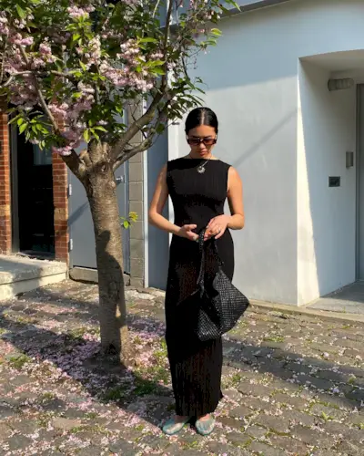 an influencer wearing a black maxi dress and Ancient Greek Sandals jelly sandals