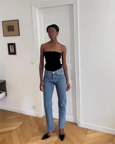 woman wearing strapless black top with slim jeans