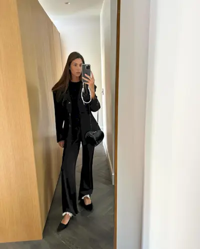 @jaimeridge wears a black blazer with matching satin wide-leg trousers.