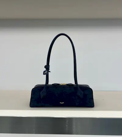 Alaïa's nubuck leather navy blue Le Teckel shoulder bag on a shelf in the brand's Paris flagship store.