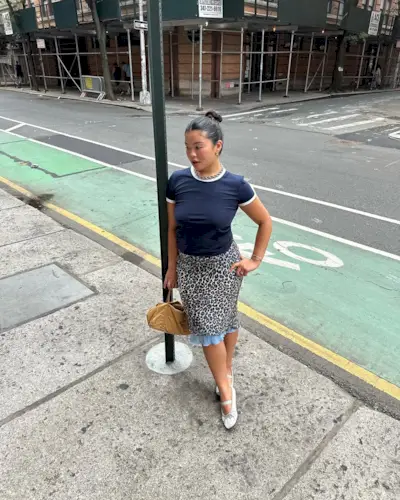 Woman wearing knee-length skirt outfit summer 2025.