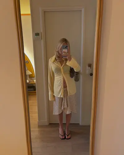 Woman wearing knee-length skirt outfit summer 2025.